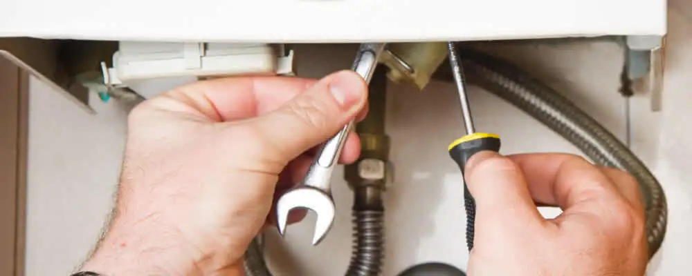 Boiler repair technician tightening pipe fittings and connections in Arlington, TX