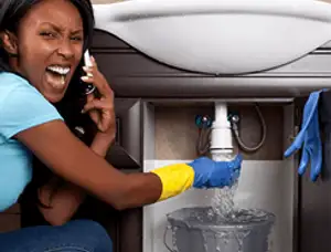 Emergency plumbing repair for a leaking sink drain under a bathroom vanity in Arlington, TX