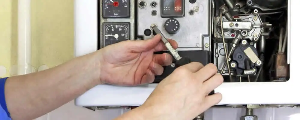 Heating repair technician adjusting boiler controls and components in Arlington, TX