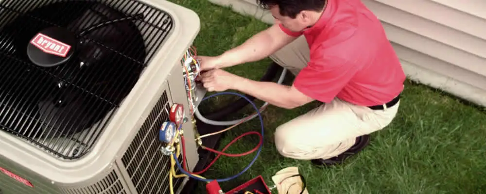 HVAC technician servicing an outdoor air conditioner unit in Arlington, TX