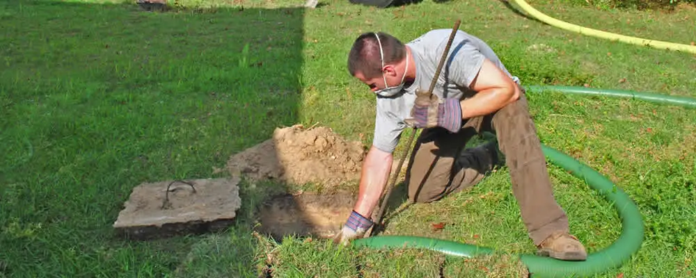 Septic pumping technician servicing a residential septic tank in Arlington, TX