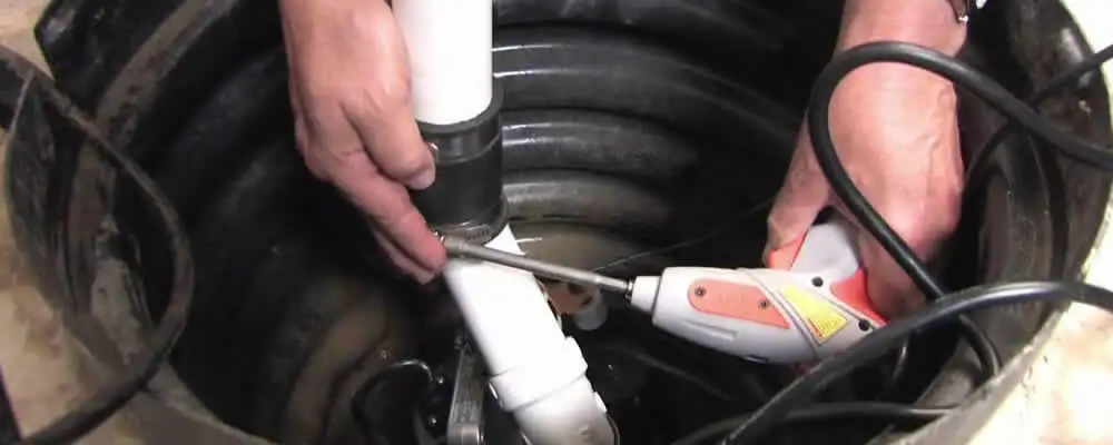 Sump pump installation technician connecting PVC discharge piping in Arlington, TX