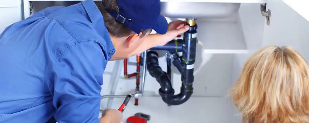 Plumber repairing under-sink drain pipes and fittings in Arlington, TX